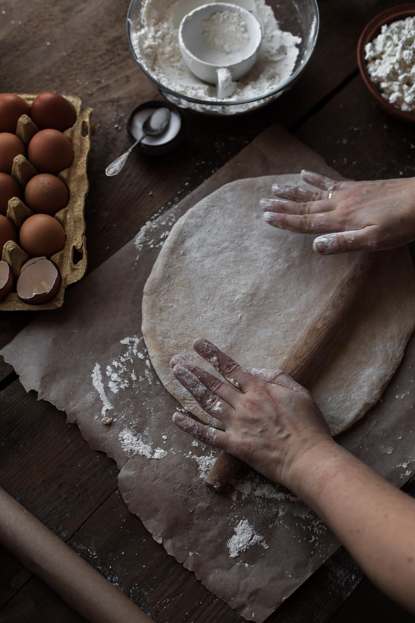 Hands kneading dough on wooden board